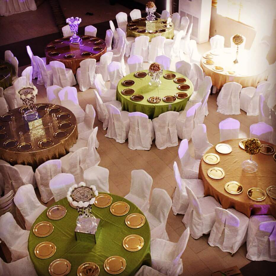 Emerald and gold themed round table settings at a Lagos social event